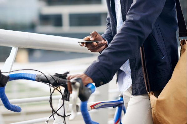 man on phone holding bike